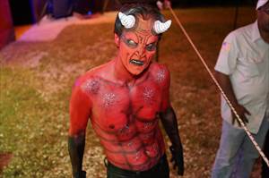 Devil with horns and full body painting poses for picture